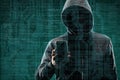 Anonymous computer hacker with a smartphone over abstract digital background. Obscured dark face in mask and hood. Data
