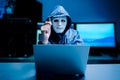 Anonymous computer hacker in white mask and hoodie. Obscured dark face holds a USB flash drive in his hands, Data thief,