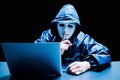 Obscured dark face making silence gesture try to hack and steal information system data from computer with usb thumb drive Royalty Free Stock Photo