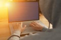 Anonymous computer programmer or hacker working typing on laptop