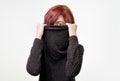 Anonymous concept. Young woman with interesting colorful hairstyle hiding her face with colar.