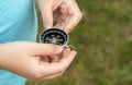 Anonymous elementary school age child holding a compass in hands, closeup, world directions, travel, journey, exploration symbol