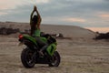 Cool woman in helmet on motorbike on beach