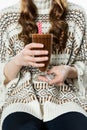 Anonymous girl holding glass of hot chocolate with red straws