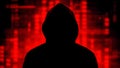 Anonymous hacker. Dark silhouette of a person in a hood against a background of blurred red holographic pixels