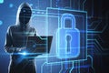Anonymous hacker with a digital padlock graphic on a blue virtual interface. Royalty Free Stock Photo
