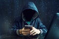 An anonymous hacker without a face uses a mobile phone to hack the system. The concept of cyber crime Royalty Free Stock Photo