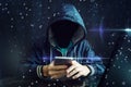 An anonymous hacker without a face uses a mobile phone to hack the system. The concept of cyber crime Royalty Free Stock Photo