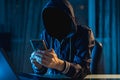 Anonymous hacker programmer uses a laptop to hack the system in the dark. Concept of cybercrime and hacking database Royalty Free Stock Photo