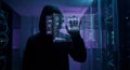 Anonymous hacker using a futuristic interface in a server room Royalty Free Stock Photo