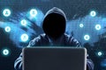 Anonymous hacker using laptop on technology background