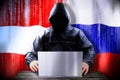 Anonymous hacker working on a laptop, flags of Austria and Russia
