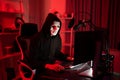 Anonymous hooded hiding identity by white face mask for hacking account data email and password information on social media