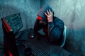 Anonymous internet hacker with mask sitting at the table and using computer Royalty Free Stock Photo
