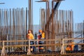 Unrecognizable workers on bridge near metal poles