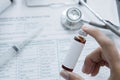 Anonymous male doctor holding a vial of medicine