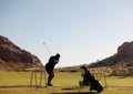 Practicing golf swing on driving range.