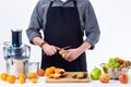 Anonymous man preparing fresh fruit juice using electric juicer, healthy lifestyle detox concept on white background. Royalty Free Stock Photo