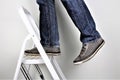 Anonymous man reaching on top of ladder climbing, indoors studio people shot