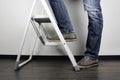 Anonymous man reaching on top of ladder climbing, indoors studio people shot