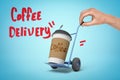 Anonymous man`s hand pulling miniature hand truck with plastic coffee cup on blue background with title `Coffee Delivery