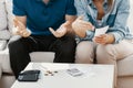 Anonymous married couple sitting in their living room calculating how many money their have got to pay bills Royalty Free Stock Photo