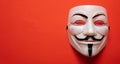 Anonymous mask against red background, closeup view