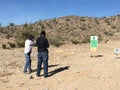 Anonymous Men Practicing Target Shooting in the Desert Royalty Free Stock Photo