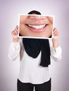 Anonymous muslim woman wearing hijab covering her face with big smile picture, happy white teeth Royalty Free Stock Photo