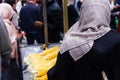 Anonymous muslim women with hijab buying corn on the cob