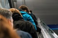 Anonymous people moving up the escalator stairs, view from behind, detail on their heads - transport concept Royalty Free Stock Photo