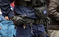 Anonymous police officer holding his hand on his equipment belt, handcuffs, baton, gun, detail, closeup. Emergency response Royalty Free Stock Photo