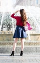 Anonymous pretty girl is standing in front of a fountain. Royalty Free Stock Photo