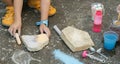 Anonymous school age girl playing with chalk and rocks outdoors, outdoor recreation, childhood sensory integration therapy. Hands