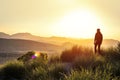 Anonymous silhouette of a man at mountain top against a foggy landscape. First man in another world. Concept of another planet Royalty Free Stock Photo