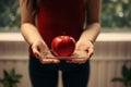 Anonymous woman checks weight, holds apple, emphasizing health and balanced lifestyle