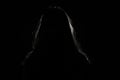 anonymous woman hiding face and identy in the dark shadow