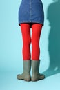 Anonymous woman in rubber boots and red tights