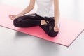 Anonymous woman sitting in lotus posture, doing yoga