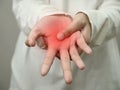 Anonymous woman touching her palm, suferring from arthritis disease, close up against grey Royalty Free Stock Photo