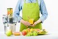 Anonymous woman wearing an apron, holding glass of freshly pressed juice, healthy lifestyle concept Royalty Free Stock Photo