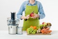 Anonymous woman wearing an apron, ready to start preparing healthy fruit juice using modern electric juicer Royalty Free Stock Photo