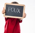 Anonymous young child holding school slate as shield against poux