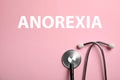 Anorexia concept. Stethoscope on pink background, top view