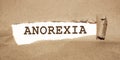 Anorexia word appearing behind brown torn paper. Eating disorders women healthcare concept