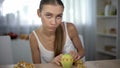 Anorexic girl measuring apple with tape, counting calories and body mass index