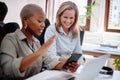 Another day of business. two businesswomen looking at something on a cellphone in an office. Royalty Free Stock Photo