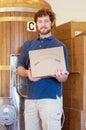 Another perfect batch. Portrait of a young brewer standing with a box of merchandise in a brewery.