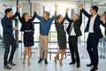 Another success for team amazing. a confident looking team of coworkers sheering together while standing in a modern Royalty Free Stock Photo