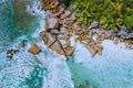 Anse Cocos beach tropical island La Digue Seychelles. Drone aerial view of foam ocean waves rolling towards the rocky Royalty Free Stock Photo